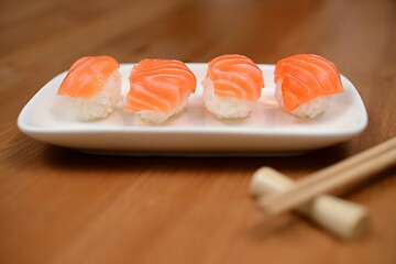 Image showing chopsticks and sushi with salmon on the mat