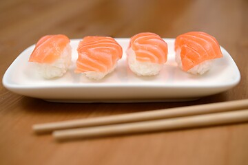 Image showing chopsticks and sushi with salmon on the mat