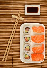 Image showing chopsticks, soy sauce and sushi on the bamboo mat