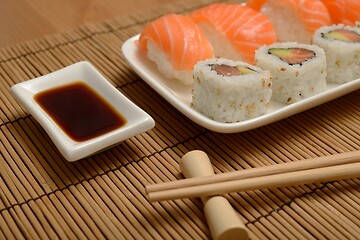 Image showing chopsticks, soy sauce and sushi on the bamboo mat