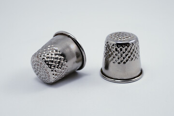 Image showing two old metal tailor thimbles on a white