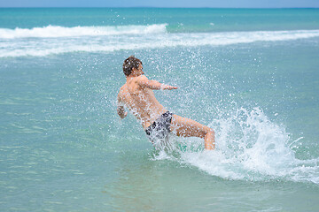 Image showing A man accelerating from the shore jumps sideways into the sea water at the resort