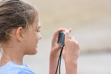 Image showing Girl photographs moments from a beach holiday on a digital camera