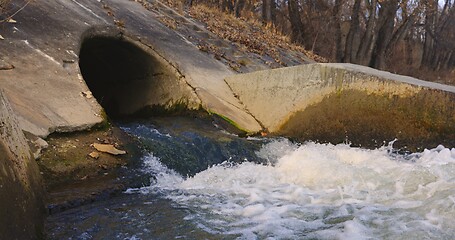 Image showing Large sewage tunnel with filth flowing out