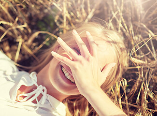 Image showing happy young woman lying on cereal field