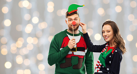 Image showing couple with christmas party props in ugly sweaters