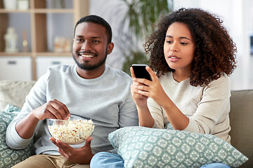 Image showing african couple with popcorn watching tv at home