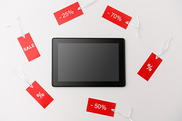 Image showing tablet computer and red tags with discount signs