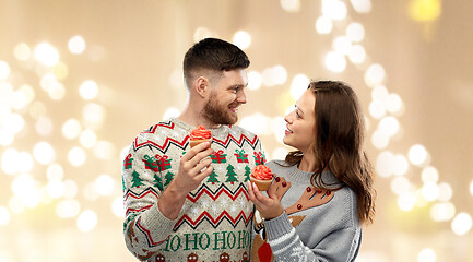 Image showing couple with cupcakes in ugly christmas sweaters