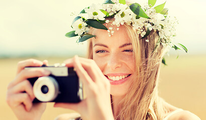 Image showing happy woman with film camera in wreath of flowers