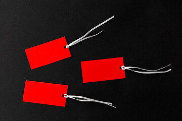 Image showing three red sale tags on black background