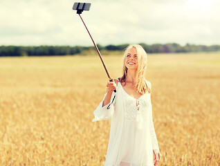 Image showing happy young woman taking selfie by smartphone