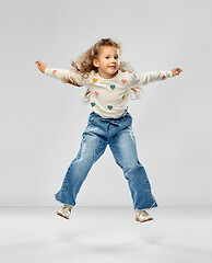 Image showing smiling little girl jumping