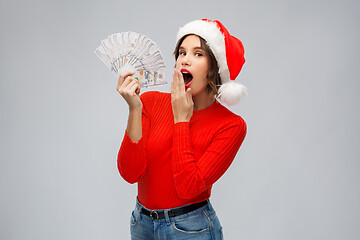 Image showing surprised woman in santa hat with money