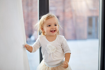 Image showing happy smiling baby girl at home window