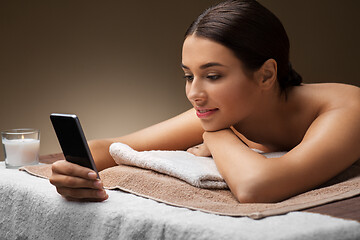 Image showing woman with smartphone at spa or massage parlor