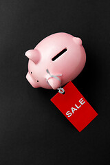 Image showing piggy bank with red sale tag on black