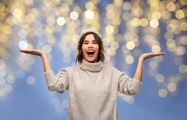 Image showing woman in winter hat holding something on christmas