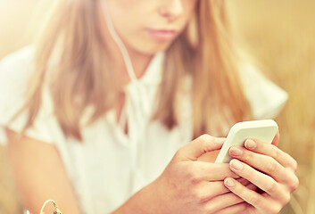 Image showing close up of woman with smartphone and earphones