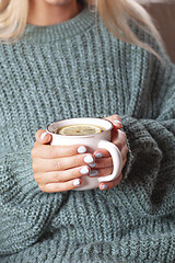 Image showing Young woman relaxing tea cup on hands.