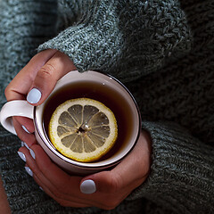 Image showing Young woman relaxing tea cup on hands.