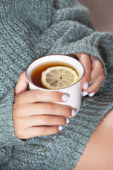 Image showing Young woman relaxing tea cup on hands.