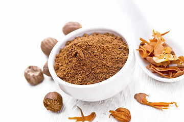 Image showing Nutmeg round in bowl and mace in spoon on white board