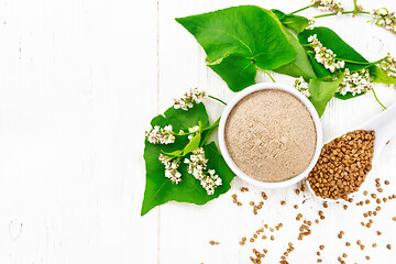 Image showing Flour buckwheat brown in bowl on board top