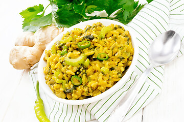 Image showing Kitchari with celery in bowl on wooden board