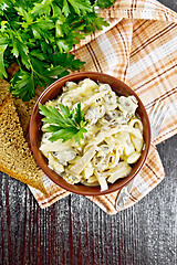 Image showing Salad with squid and champignons in bowl on dark board top