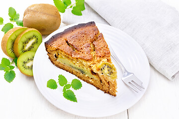 Image showing Pie with kiwi in plate on wooden board