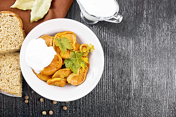 Image showing Mushrooms salted with sour cream in plate on black board top