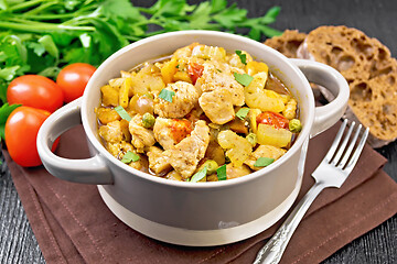 Image showing Chicken with vegetables and peas in saucepan on table