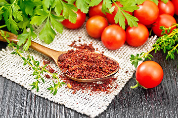 Image showing Tomatoes dried in spoon on dark board