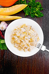 Image showing Pumpkin with sour cream sauce in plate on wooden table top