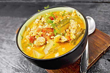 Image showing Ragout of zucchini and minced meat in bowl on dark board