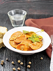 Image showing Mushrooms salted in plate with bread on black board