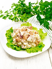 Image showing Salad of salmon and cucumber in plate on light wooden board