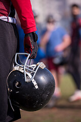 Image showing American football player holding helmet