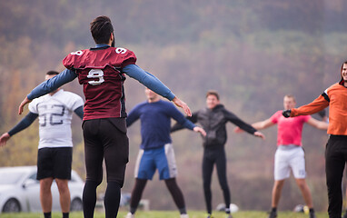 Image showing american football players stretching and warming up