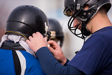 Image showing American football players checking helmets