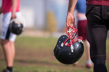 Image showing American football player holding helmet