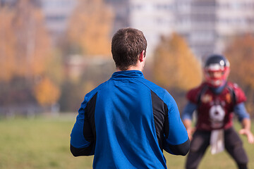 Image showing american football team with coach in action