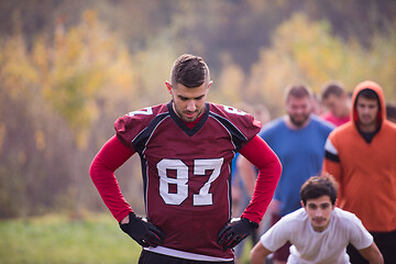 Image showing american football players stretching and warming up