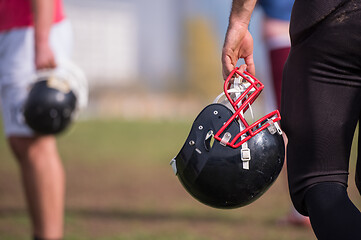 Image showing American football player holding helmet