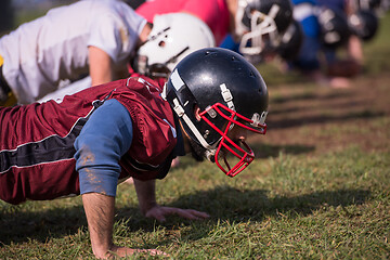 Image showing american football team doing push ups