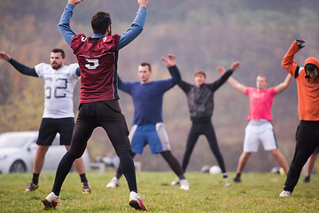 Image showing american football players stretching and warming up