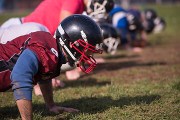 Image showing american football team doing push ups