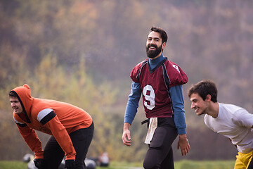 Image showing american football players stretching and warming up