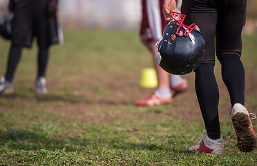 Image showing American football player holding helmet